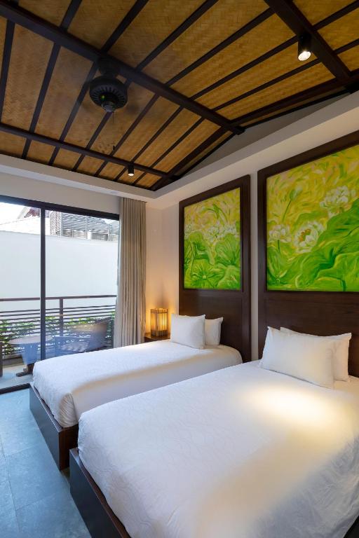 Postel nebo postele na pokoji v ubytování Nghê Prana Hotel and Spa Hoi An