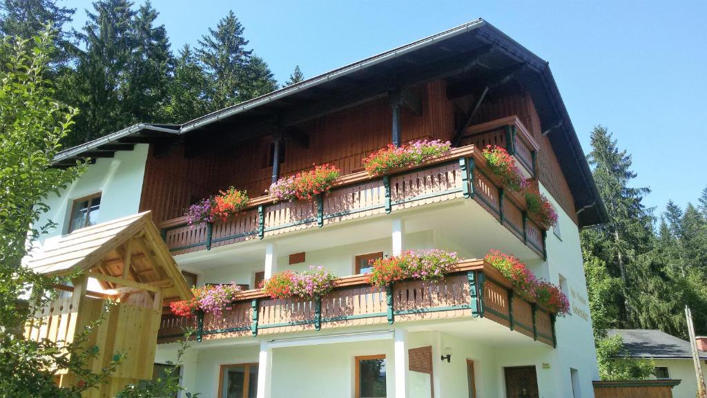 ein Gebäude mit Blumenkästen auf dem Balkon in der Unterkunft Appartement-Pension Familie Gewessler in Bad Mitterndorf
