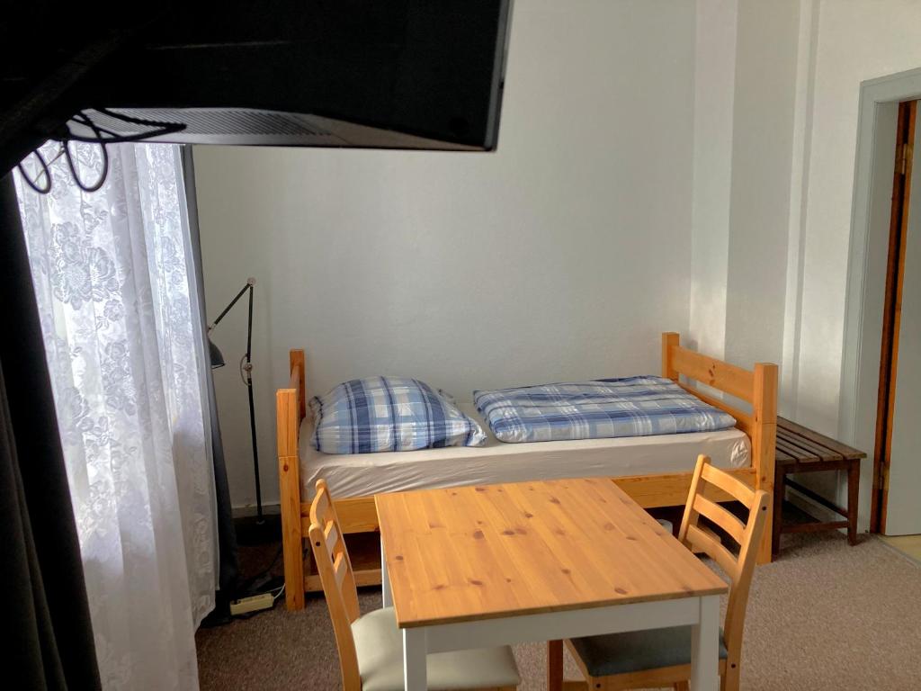 Dormitorio pequeño con cama, mesa, mesa y silla en Mini Apartment, en Osterholz-Scharmbeck