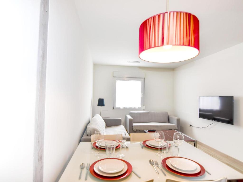 ein Wohnzimmer mit einem Tisch und einem Sofa in der Unterkunft Precioso apartamento reformado en el sardinero in Santander