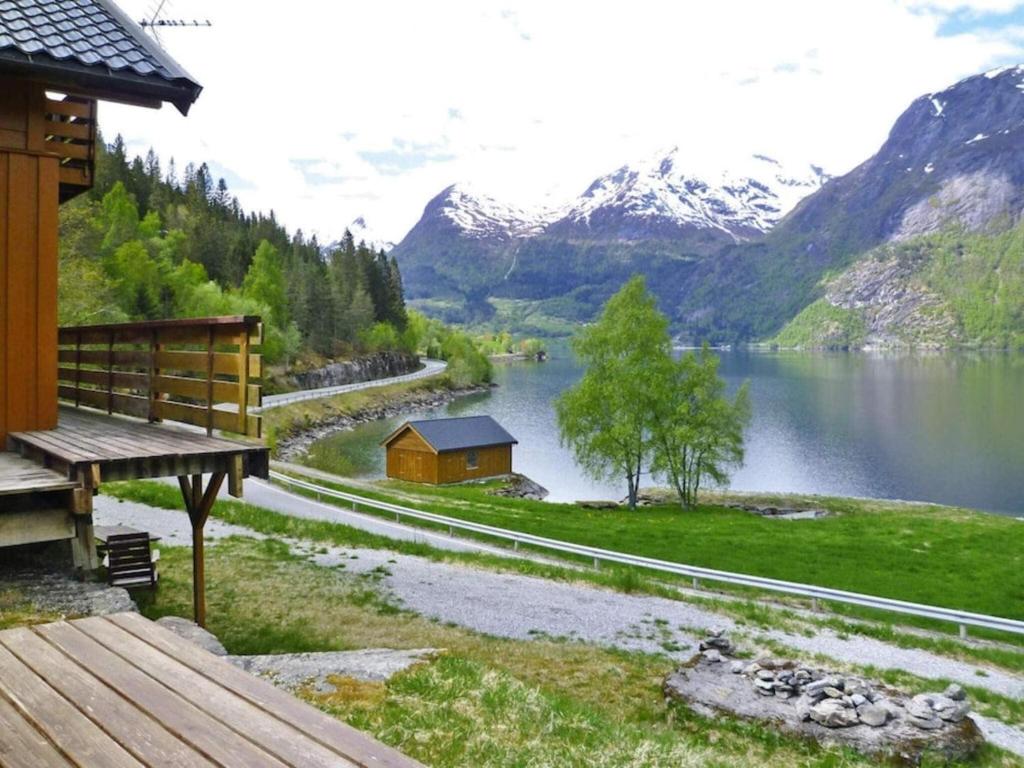 uma vista para um lago com uma casa e montanhas em Apartment STRYN II em Stryn