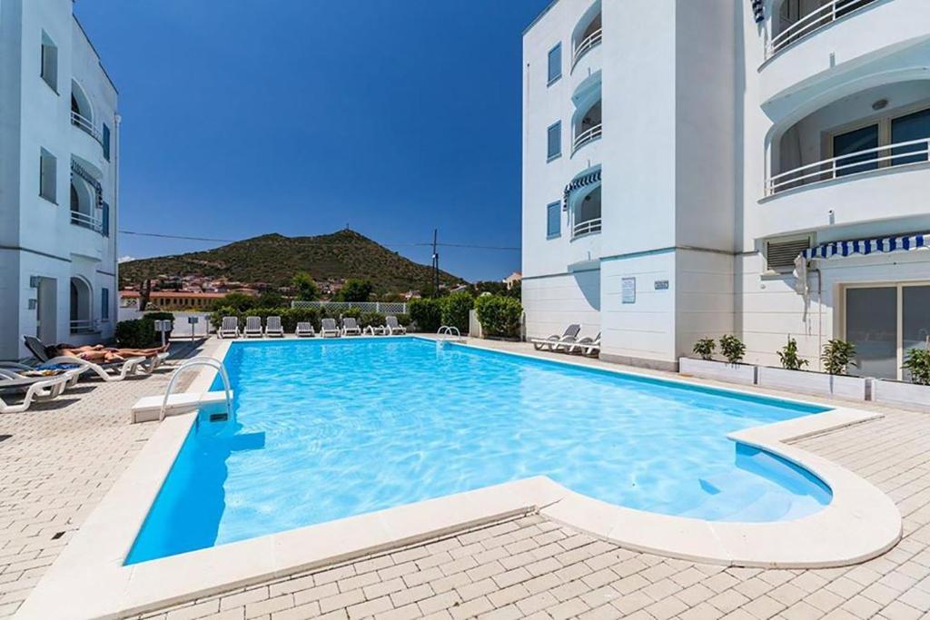 uma grande piscina ao lado de um edifício em Le Residenze Blu Sardinia em La Caletta