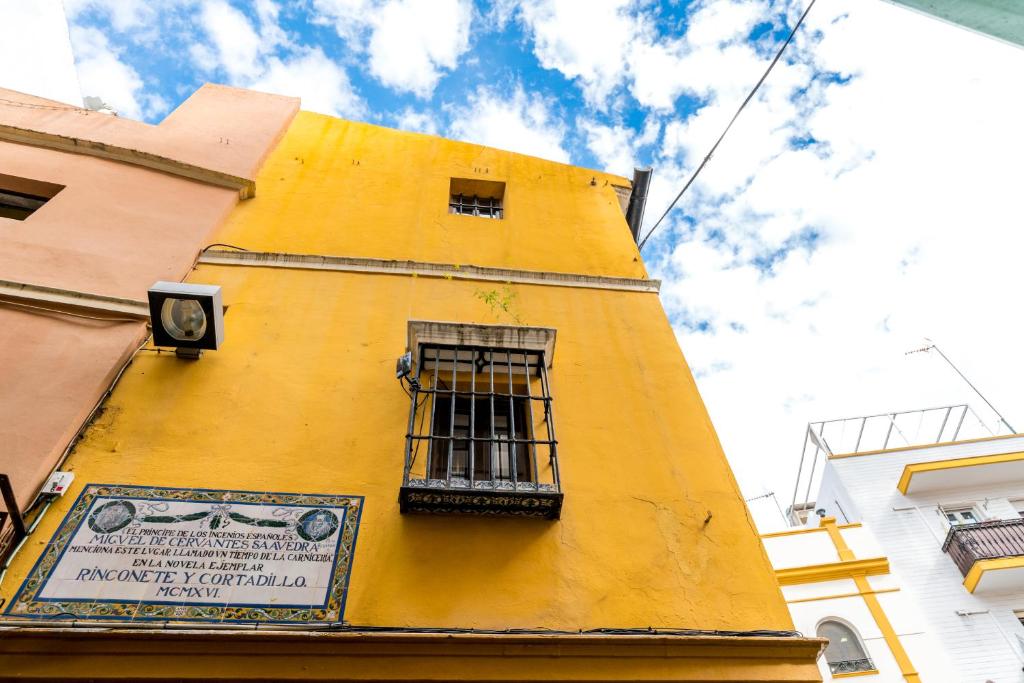 un edificio amarillo con una ventana en el lateral en Casa Ispal Alfalfa, en Sevilla