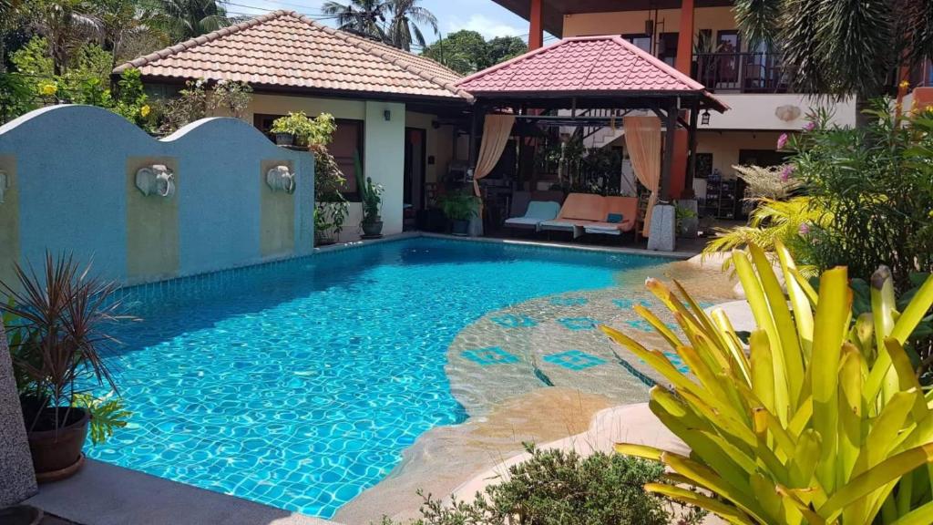 a swimming pool in front of a house at Baan Tropicana in Mae Nam