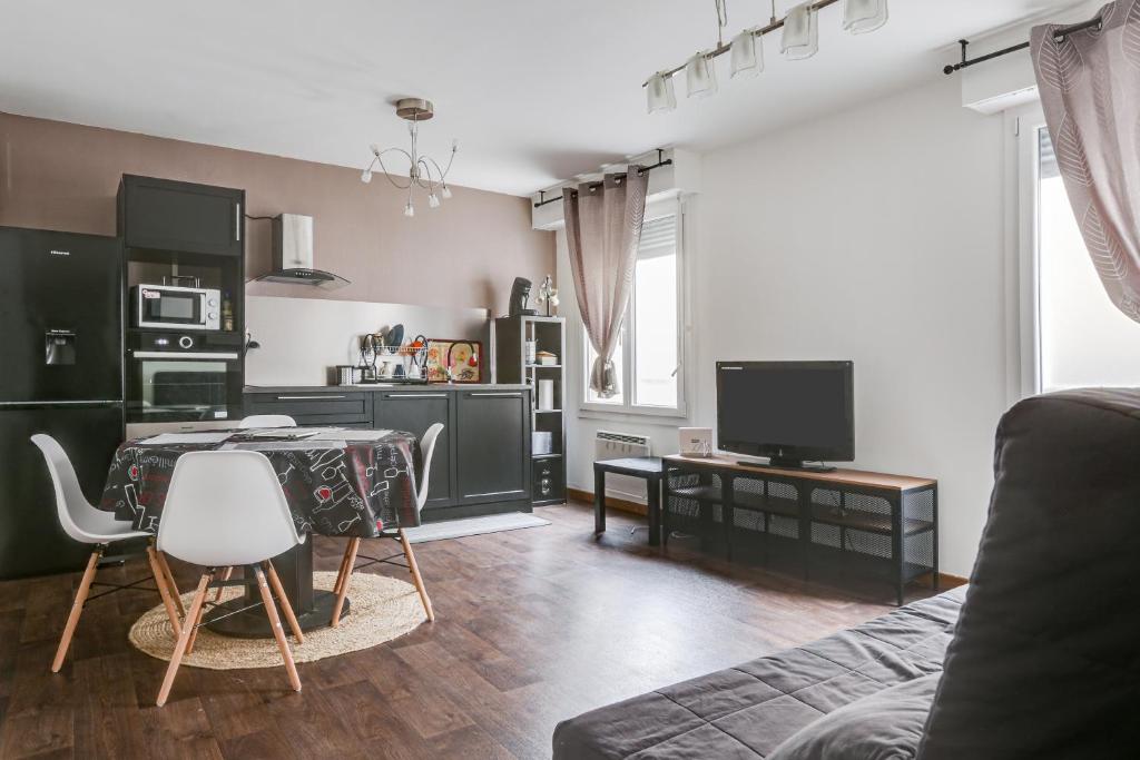 un salon avec une table et une télévision dans l'établissement L'Amarillo, à Nancy