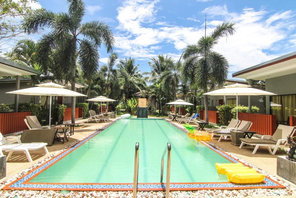 a pool with chairs and umbrellas at a resort at ViVi Hotel Resort in Phuket Town