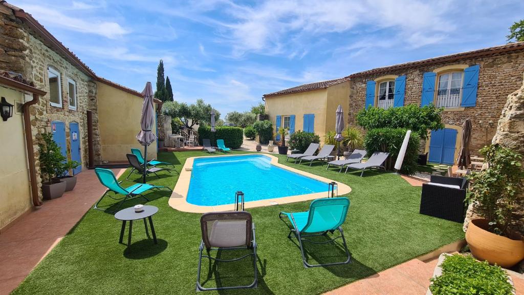 una piscina en un patio con sillas y mesa en La Bastide Saint Bach en Suze-la-Rousse