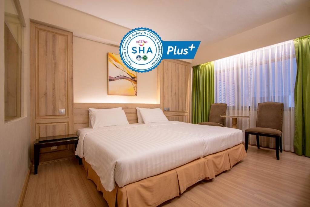 a hotel room with a bed and a sign that says slab plus at The Residence Rajtaevee Hotel in Bangkok