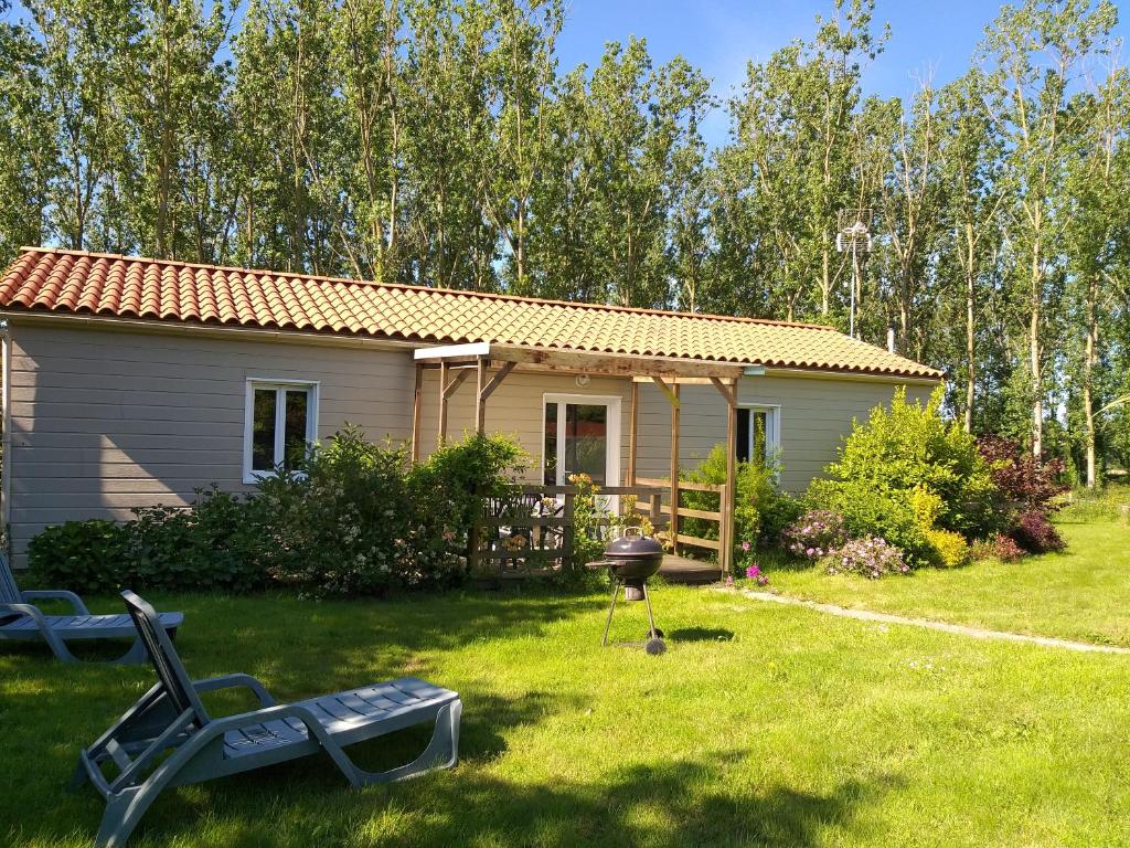 une petite maison avec un barbecue dans la cour dans l'établissement Les Gîtes de Sophie 85 gite Capucine, à Saint-Gervais