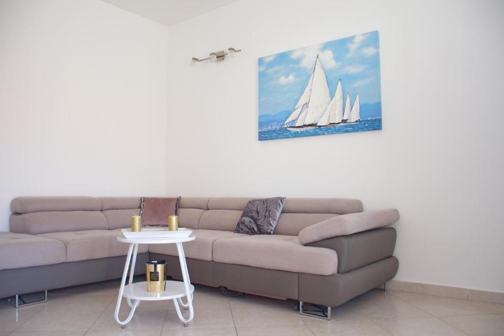 a living room with a couch and a sail boat on the wall at Summer Fun Apartment in Novalja