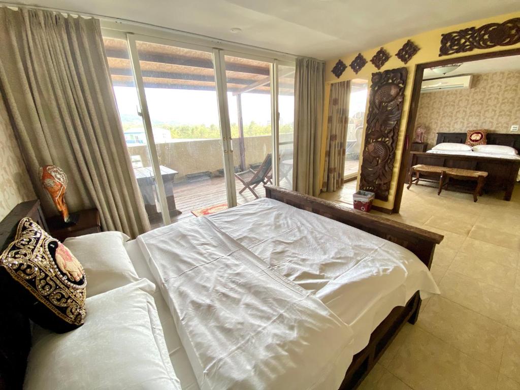恆春的住宿－墾丁171幸福旅店 ，卧室设有一张大白色床和阳台