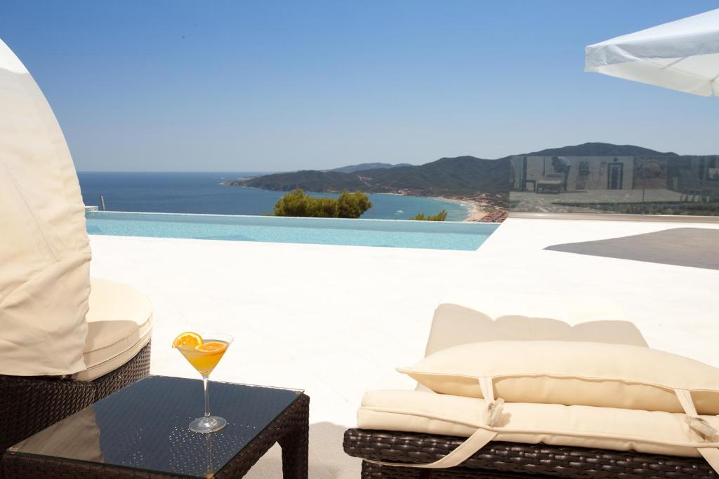 een tafel met een drankje op het balkon bij Villa White Pearl in Sarti