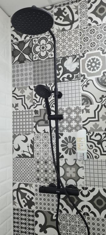 a bathroom with a black and white patterned wall at Centrum Apartman LEYLA I in Bardejov