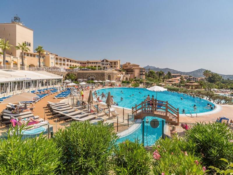 a large swimming pool with chaise lounges and a resort at Superbe studio 4&#47;5 pers dans résidence cap esterel in Agay - Saint Raphael