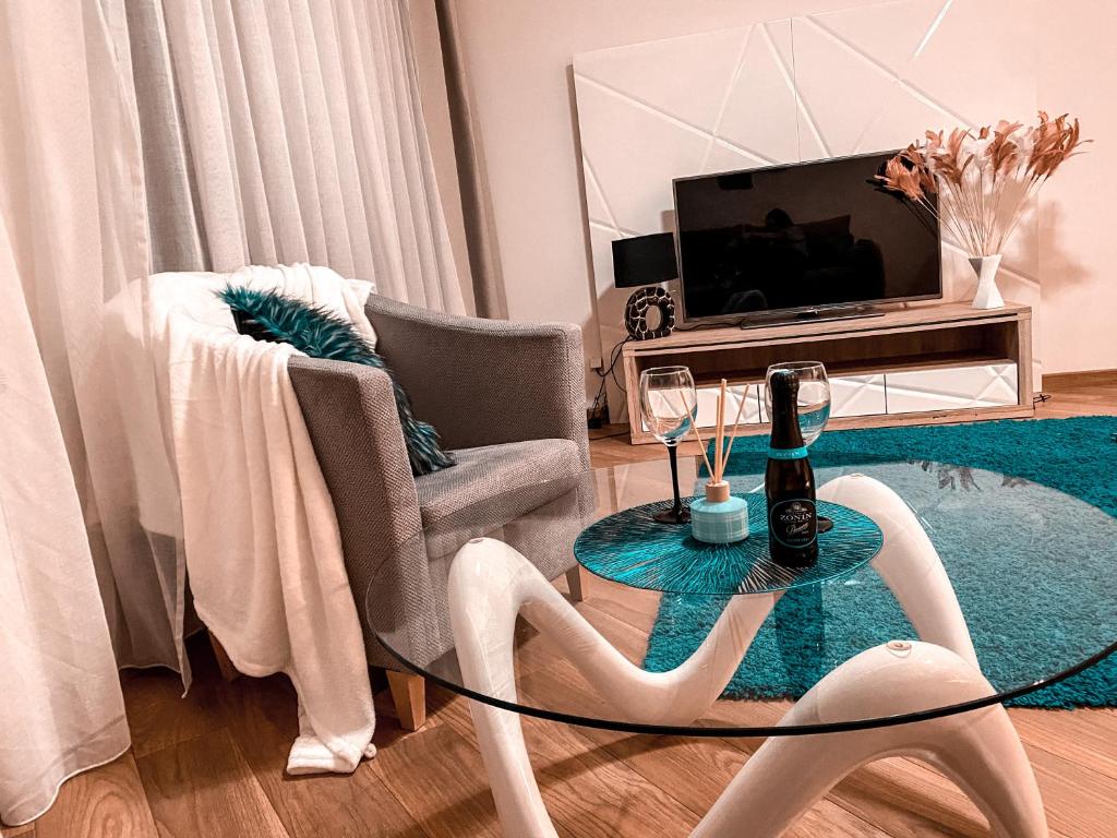 ein Wohnzimmer mit einem Glastisch und einem TV in der Unterkunft Apartament Solna 80 - Centrum Miasta z podziemnym garażem in Kielce