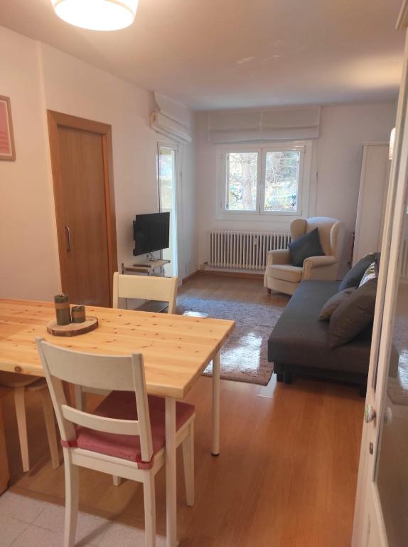 sala de estar con mesa y sofá en Apartamento bonito Molina Alp, en La Molina