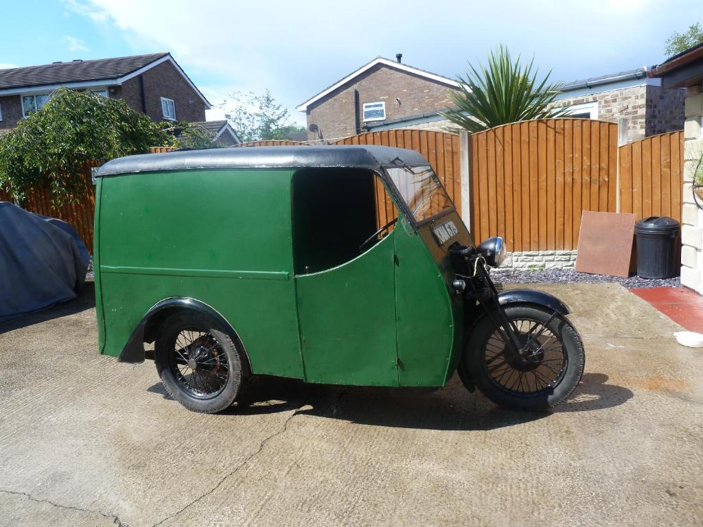 a small green car parked in a driveway at Smithy lodge Guest House in Leyland