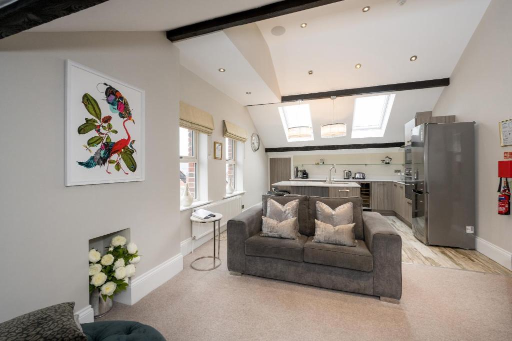 a living room with a couch and a kitchen at Harrogate Serviced Apartments - St George's Five in Harrogate