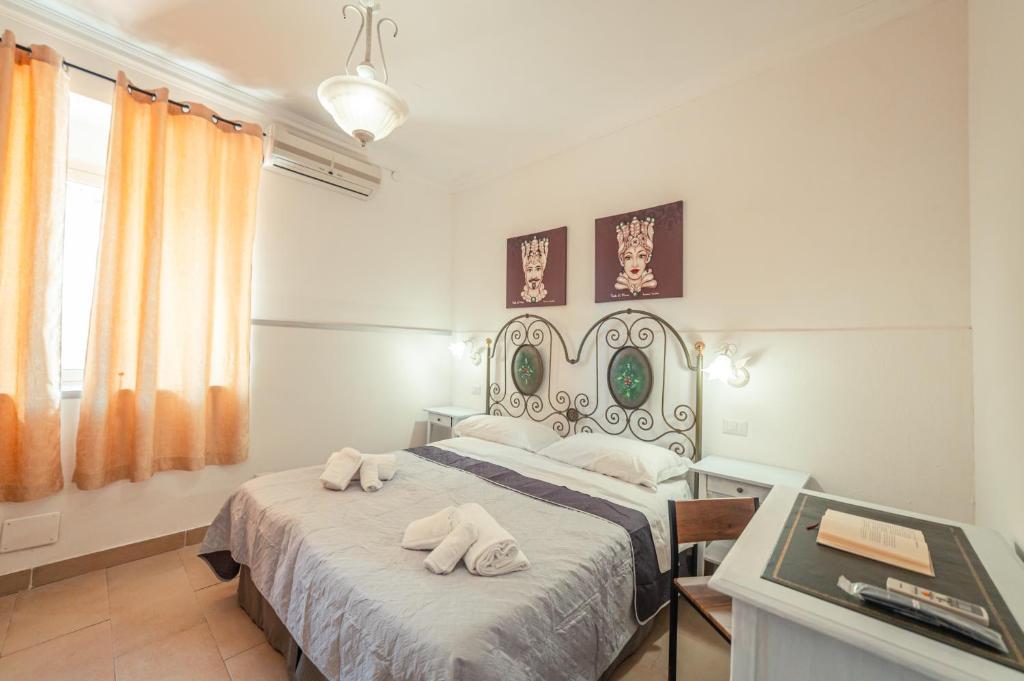 a bedroom with a bed with two towels on it at Taormina Garden Hotel in Taormina