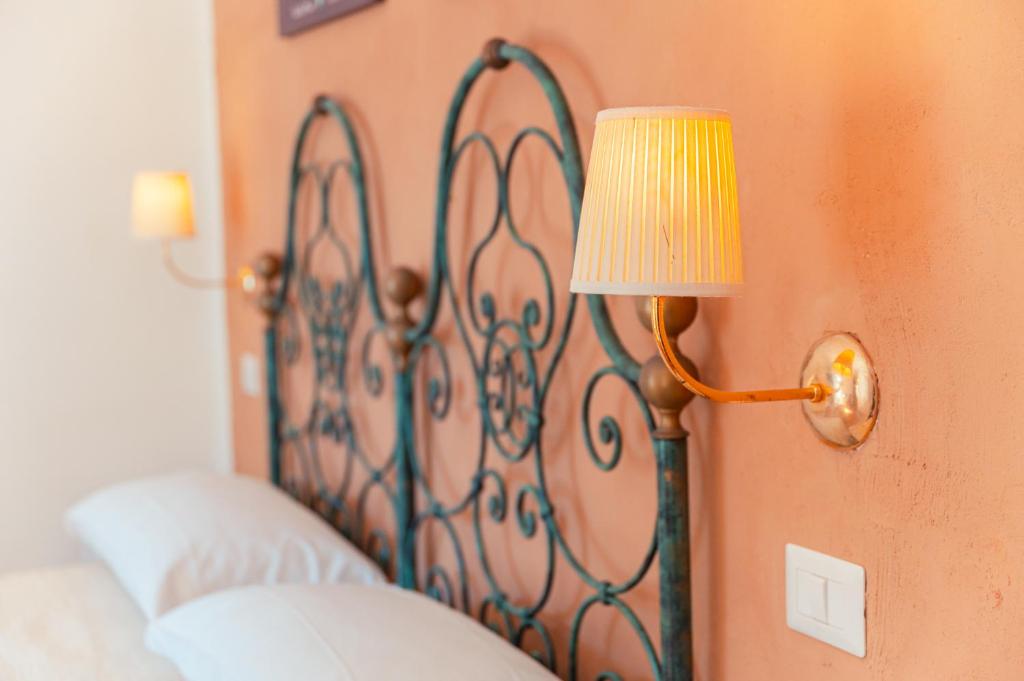 a lamp hanging on a wall next to a bed at Taormina Garden Hotel in Taormina