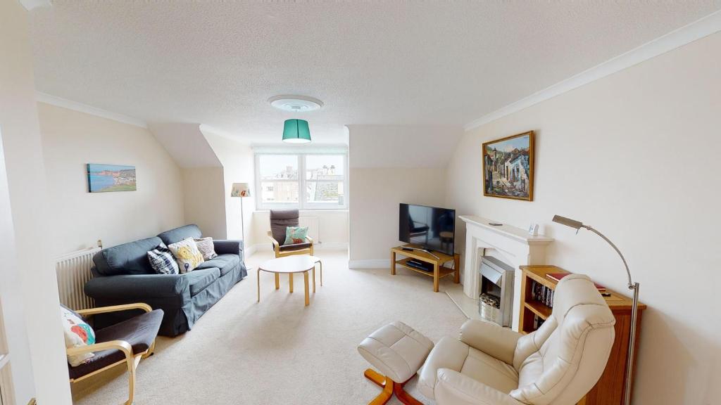 uma sala de estar com um sofá e uma lareira em The Retreat em Sidmouth