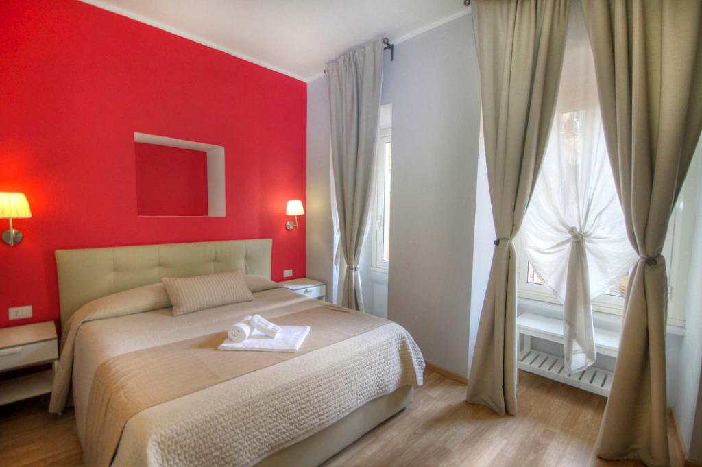 een rode slaapkamer met een bed en een raam bij Sweet Home Faleria in Rome