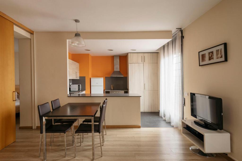 comedor y cocina con mesa y sillas en Barcelona Apartment Villarroel, en Barcelona