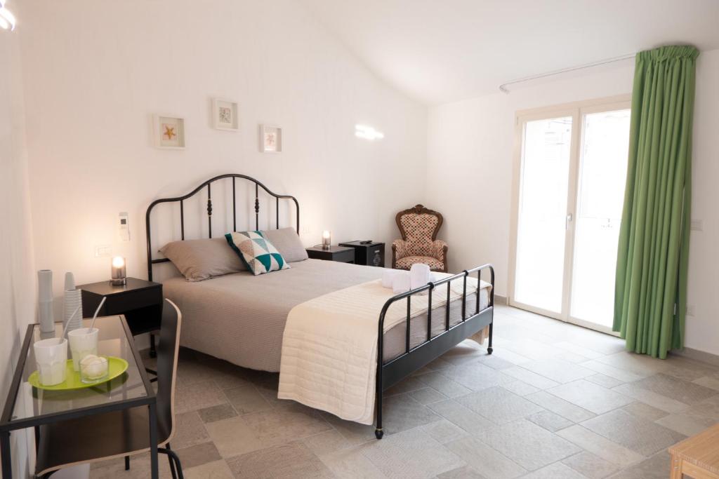 a bedroom with a bed and a table and a window at Almasarda in Olbia