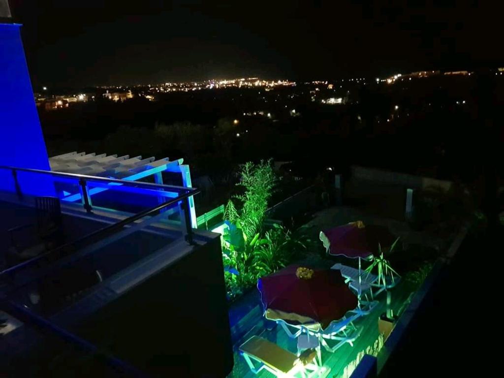 patio na dachu z parasolami w nocy w obiekcie APHRODITE Lux sea view Villa w mieście Koskinou