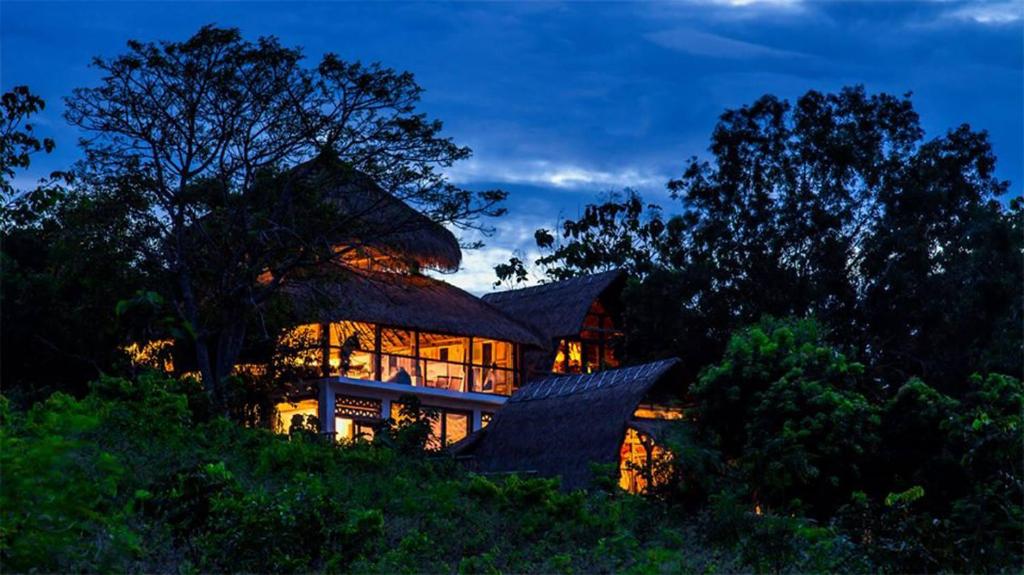 une grande maison au sommet d'une colline la nuit dans l'établissement Vertical House Bali, à Uluwatu