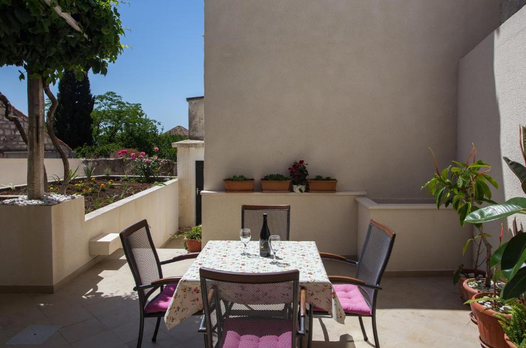 a table and chairs on a patio with plants at Apartments Aurelia in Dubrovnik