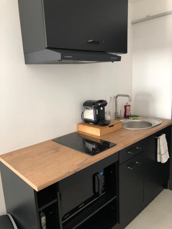 a kitchen counter with a sink and a microwave at Sainte Cécile 6 &#47; Studio Elégant et Central in Vichy