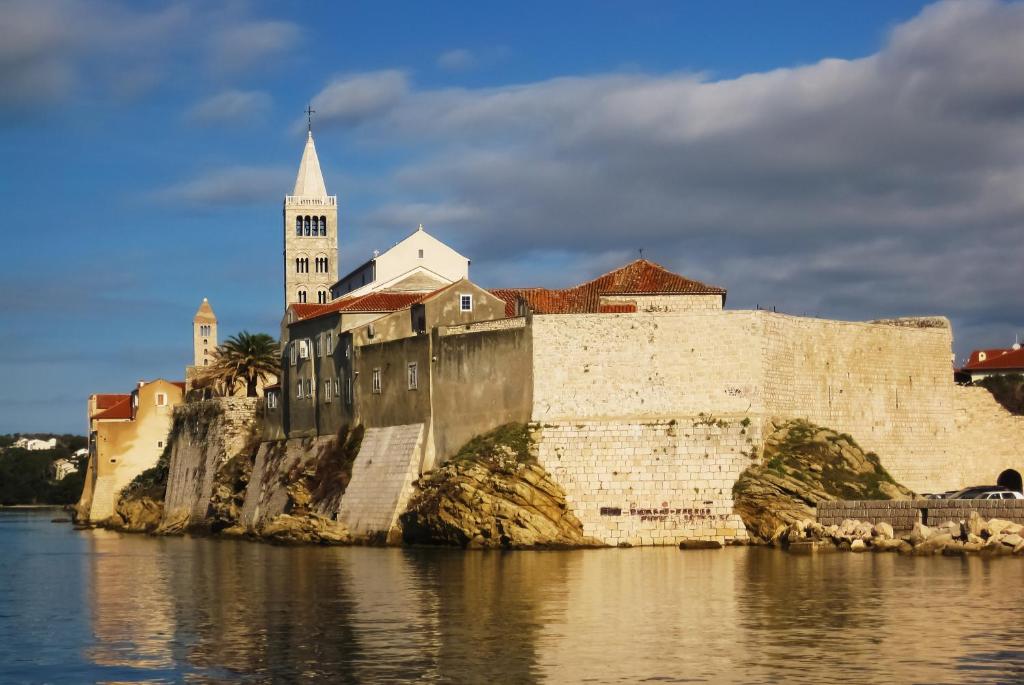 a castle on the side of a body of water at Toncica Sunny terrace with seaview and shaded BBQ area in Metajna