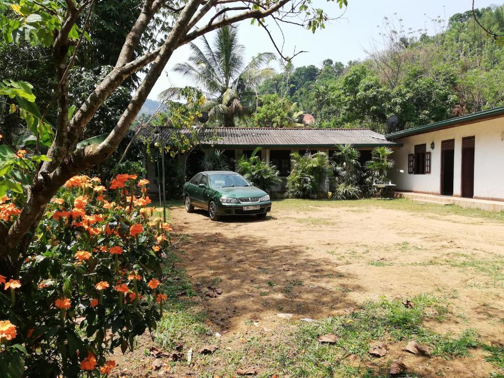 a green car parked in front of a house at Leaf Guest House in Gampola