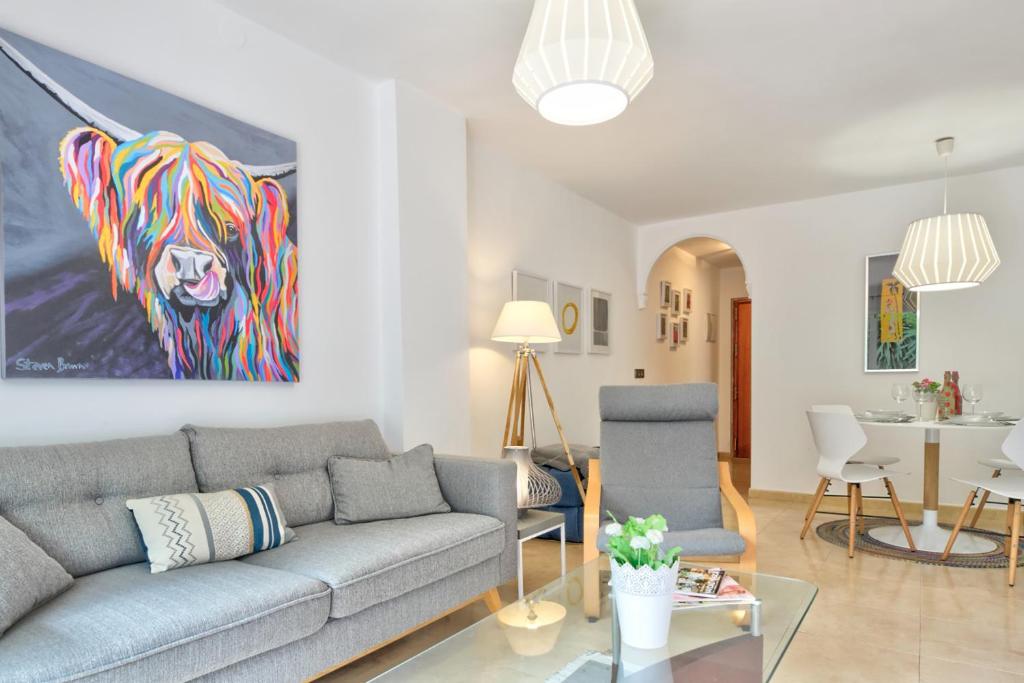 uma sala de estar com um sofá e uma pintura de um leão em MalagadeVacaciones - Muriel em Málaga