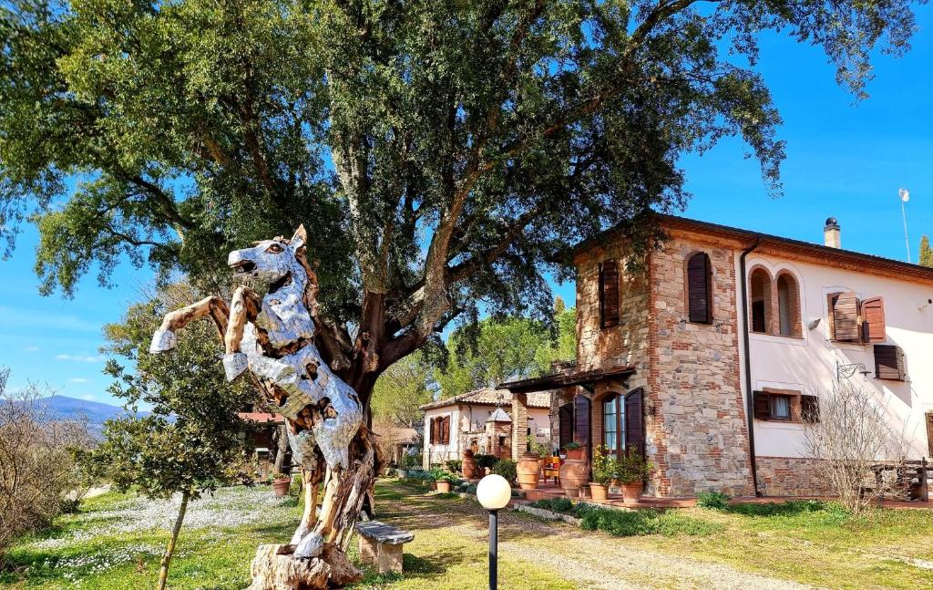 eine Statue einer Giraffe neben einem Baum in der Unterkunft Agriturismo Poggio La Buca in Civitella Marittima