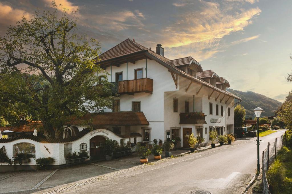 duży biały dom z balkonem na ulicy w obiekcie Pension Hinterleithner w mieście Persenbeug
