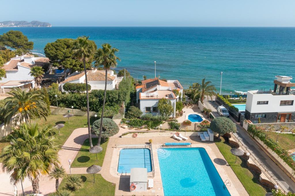 an aerial view of a house with a swimming pool and the ocean at Aparto Residence Galetamar in Calpe