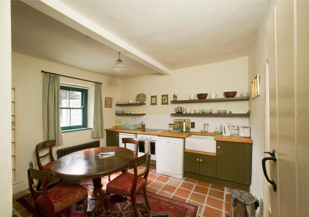 uma cozinha com uma mesa e uma mesa e cadeiras em Castletown Gate House em Celbridge