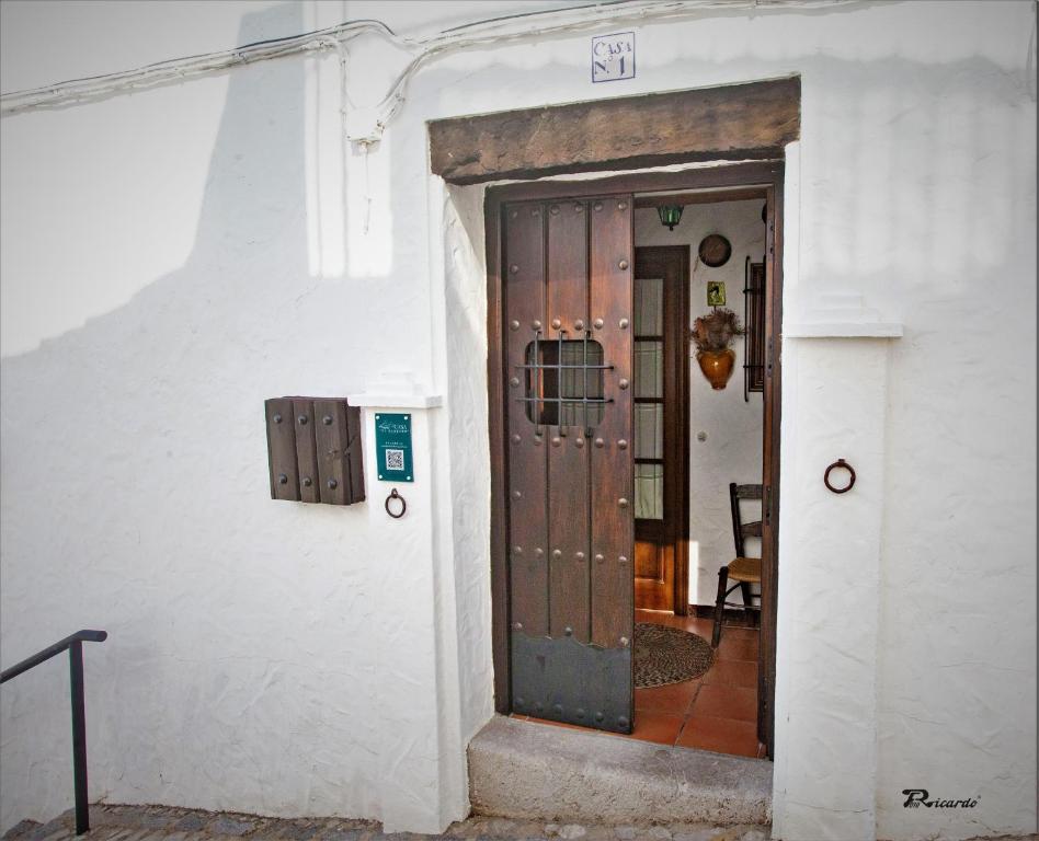 una puerta a un edificio blanco con una puerta Sidx sidx sidx sidx en Casa El Barbero 1810 en Benaocaz