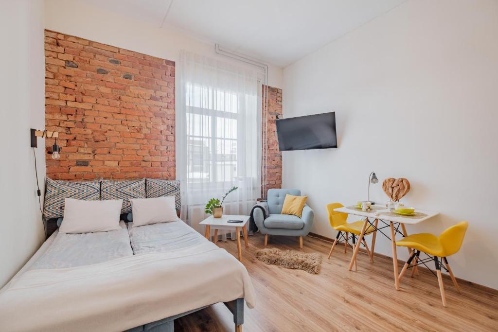 a bedroom with a bed and a brick wall at Filosoofi 1 Studio Apartments in Tartu