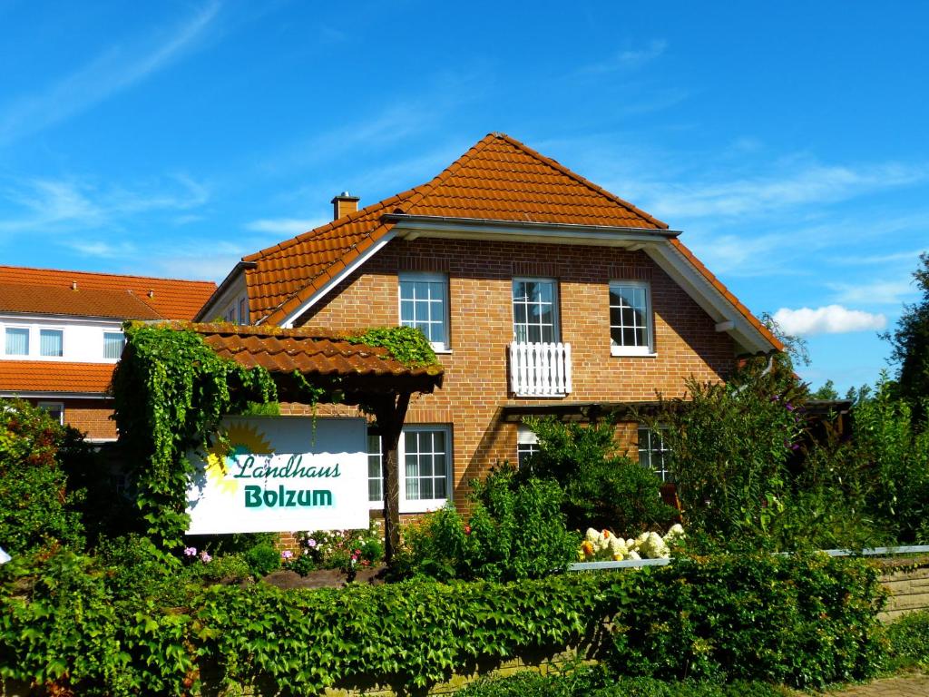 une maison avec un panneau devant elle dans l'établissement Landhaus Bolzum, à Sehnde