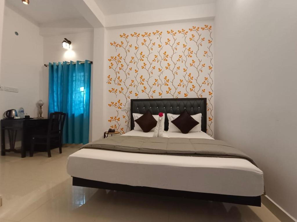 a bedroom with a large bed with a blue curtain at VILLA DE SRIVAARI RESIDENCY in Puducherry