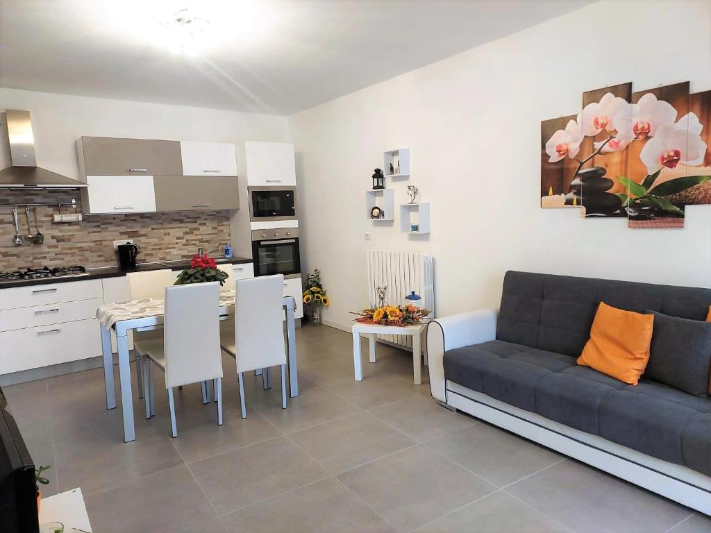 Una sala de estar con un sofá y una mesa y una cocina. en Casa Edda, en Malcesine