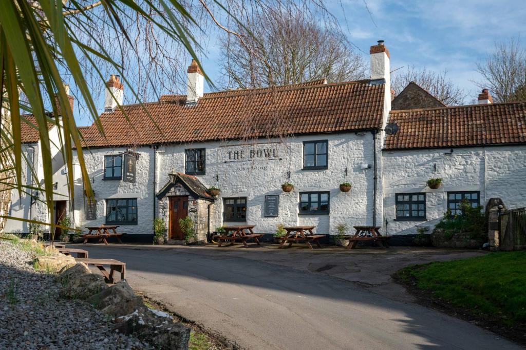 - un bâtiment blanc avec des tables de pique-nique devant dans l'établissement Bowl Inn, à Almondsbury