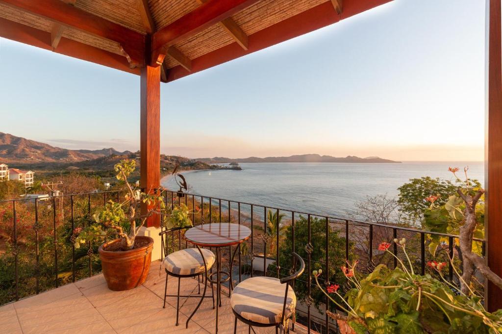 d'un balcon avec une table et des chaises et une vue sur l'océan. dans l'établissement Luxury Flamingo villa with outdoor bar - pool and magnificent views, à Playa Flamingo