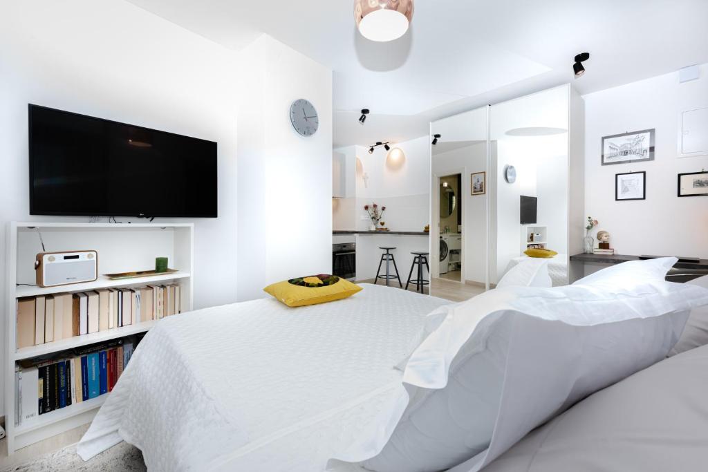 um quarto branco com uma cama grande e uma televisão de ecrã plano em Apartment "Dida" with Free Private Parking em Solin