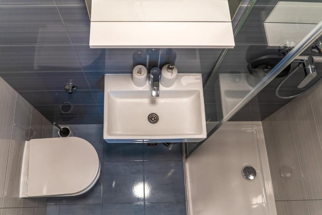 a bathroom with a white sink and a toilet at Comfort Apartment Dorin in Makarska