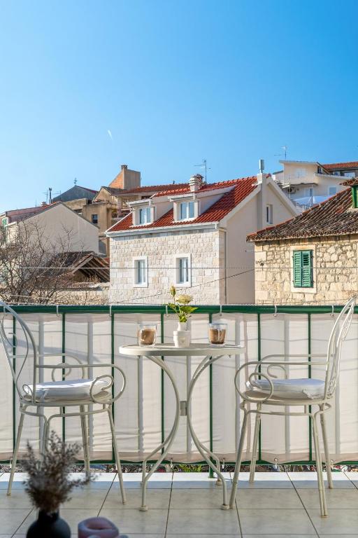 a patio with two chairs and a table on a balcony at Comfort Apartment Dorin in Makarska