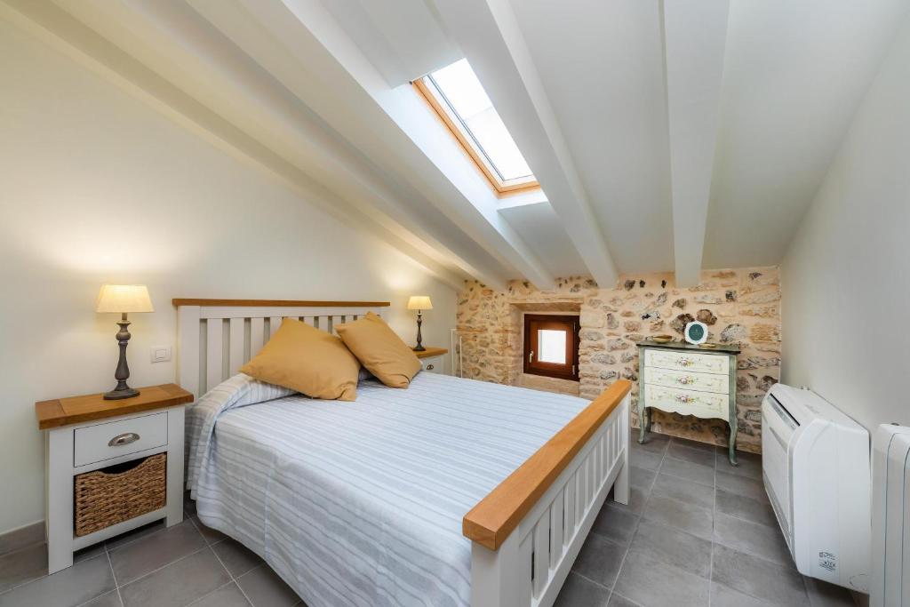 a bedroom with a bed and a stone wall at Casa Abeurador in Artá